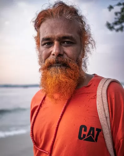Web20250311182835 Street portrait of an artist with an orange coloured beard and orange t-shirt on the seafront