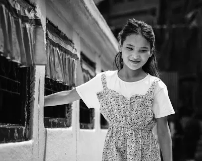 DSCF9043 Monochrome image of local girl in dress and white t-shirt spinning prayer wheels at temple near Kathmandu