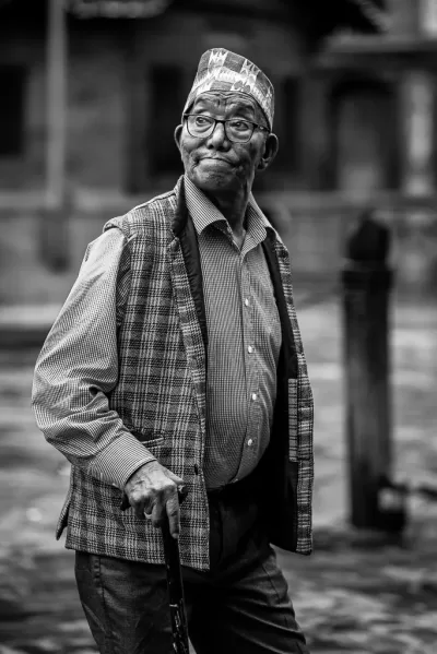 Web20240601175331 Black and white candid street portrait of local Nepalese man wearing a traditional hat and waistcoat
